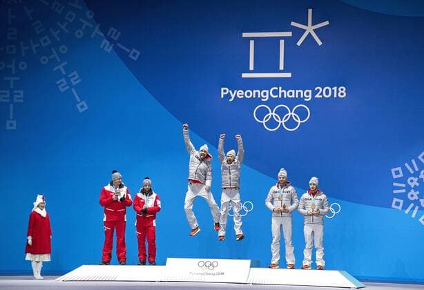 Gold medalist Germany s Tobias Wendl and Tobias Arlt jump in celebration alongside Silver medalist (L) Austria s Peter Penz and Georg Fischler and bronze medalist Germany s Toni Eggert and Sascha Benecken during the medal ceremony for Luge Doubles at the Pyeongchang 2018 Winter Olympics in Pyeongchang, South Korea, on February 16, 2018.  OLY20180216361 KEVINxDIETSCH