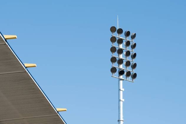 Construction of the new flood light poles in the Ernst Abbe Sportfeld home stadium of FC Carl Zeiss Jena on 16 February 2018 look at the field of one of the new towers in addition to the main grandstand of Ernst Abbe spor field
