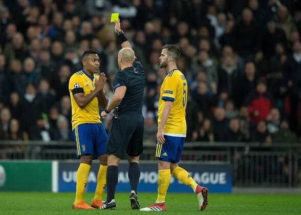 Alex Sandro of Juventus is shown the yellow card by Referee Szymon Marciniak (POL) during the UEFA Champions League round of 16 leg 2of2 match between Tottenham Hotspur and Juventus at Wembley Stadium, London, England on 7 March 2018. Copyright: xVincexMignottx PMI-1866-0056