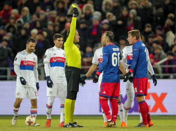 MOSCOW, RUSSIA â€“ MARCH 8, 2018: Referee Antonio Mateu Lahoz (C) shows a yellow card to CSKA Moscow s Kirill Nababkin (R) during the first leg of their 2017 18 UEFA Europa League Round of 16 football match against Lyon at VEB Arena Stadium. Sergei Bobylev TASS  TS077128