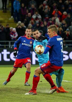 MOSCOW, RUSSIA â€“ MARCH 8, 2018: CSKA Moscow s Alan Dzagoev (L), Pontus Wernbloom (R) and Lyon s goalkeeper Anthony Lopes (C) fight for the ball in the first leg of their 2017 18 UEFA Europa League Round of 16 football match at VEB Arena Stadium. Mikhail Tereshchenko TASS  TS07712D