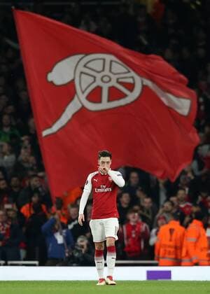 Bilder des Tages - SPORT 15th March 2018, Emirates Stadium, London, England; UEFA Europa League football, round of 16 second leg, Arsenal versus AC Milan; Mesut Ozil of Arsenal looks on in front of a huge Gunners flag  ActionPlus12001849