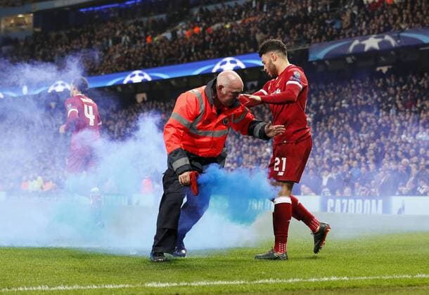 A Manchester City steward gets rid of a smoke bomb as Liverpool s players celebrate their opening goal during the Champions League Quarter Final 2nd Leg match at the Etihad Stadium, Manchester. Picture date: 10th April 2018. Picture credit should read: David Klein Sportimage EDITORIAL USE ONLY. No use with unauthorised audio, video, data, fixture lists, club league logos or live services. Online in-match use limited to 120 images, no video emulation. No use in betting, games or single club league player publications.