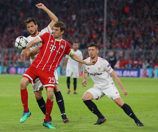 SOCCER - UEFA CL, Bayern vs Sevilla MUNICH,GERMANY,11.APR.18 - SOCCER - UEFA Champions League, quarter finals, FC Bayern Muenchen vs FC Sevilla. Image shows Thomas Mueller (Bayern), Franco Vazquez and Clement Lenglet (Sevilla). GEPAxpictures xThomasxBachun
