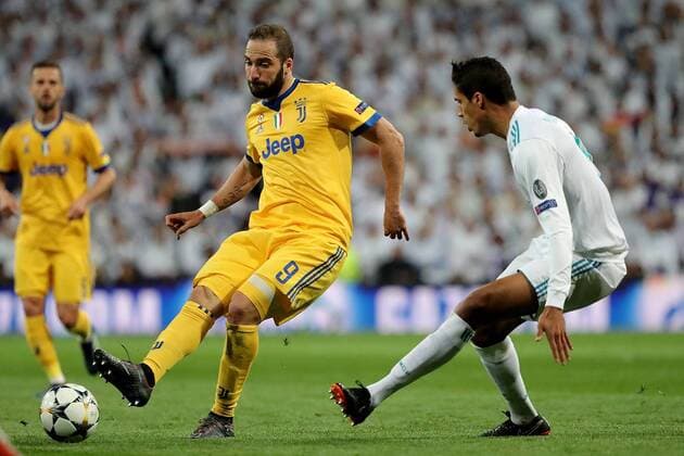 Gonzalo Higuain of Juventus (L) challenged by Raphael Varane of Real Madrid (R) during the UEFA Champions League Quarter-Finals second leg match at the Estadio Santiago Bernabeu in Madrid, Spain on 11 April 2018 Real Madrid v Juventus UCL-17_18