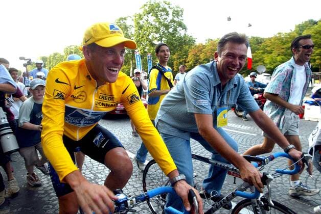 NO MAGS-NO SALES-NO INTERNET BRU129 - - PARIS, FRANCE : Yellow jersey, leader of the US Postal Service team, US Lance Armstrong, flanked by Belgian sports director Johan Bruyneel (R) parades on the Champs Elysees after the last stage of the 89th Tour de France in Paris, Sunday 28 July 2002. REPORTERS - MICHELxGOUVERNEUR  x1009138x