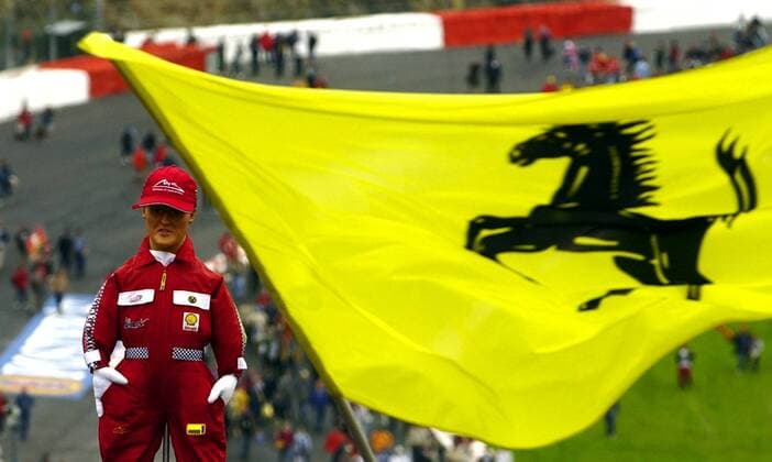 BRU270 - - FRANCORCHAMPS, BELGIUM : A huge Ferrari flag waves besides a model of German Michael Schumacher at the end of the Belgian F1 Grand Prix, 01 September 2002, on the race track of Spa - Francorchamps. German World Champion Michael Schumacher won ahead of his teammate Rubens Barrichello and Colombian Juan Pablo Montoya of Williams-BMW. BENOITxDOPPAGNE  x1034683x