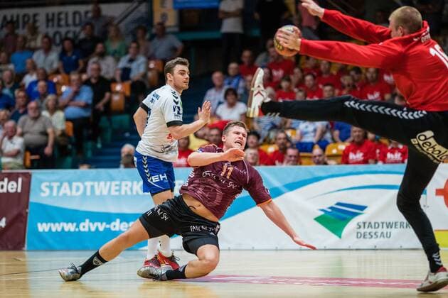 Robin John 11 of Eintracht Hildesheim throwing on goal by Philip Ambrosius 16 of Dessau Rosslauer HV 06 with Jan Zahradnicek 33 of Dessau Rosslauer HV 06 during the match in the DKB Handball 2 Bundesliga between Dessau Rosslauer HV 06 and Eintracht Hildesheim in the Anhalt Arena on April 20 2018 in Bauhausstadt Dessau Saxony Anhalt Germany HB 2BL Dessau Rosslauer HV 06 Eintracht Hildesheim Bauhausstadt Dessau Copyright: xEIBNER HartmutxBoesenerx EP_HBR