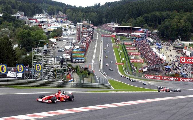 BRU37 - - FRANCORCHAMPS, BELGIUM : (FILES) A picture dated 01 September 2002 shows shows German Formula One World Champion Michael Schumacher (L) steering his Ferrari car during the first lap in the raidillon on the race track of Spa-Francorchamps. Walloon Minister of Economy Serge Kubla announced Saturday 02 August 2003 that Formula One heads agreed to come back for a Belgian F1 Grand Prix after a controversial law forbidding advertising for tobacco was modified last week by the Belgian Parliament. The Grand Prix of Belgium is not taking place in the 2003 calendar. GUYxMOSSAY  x1346691x