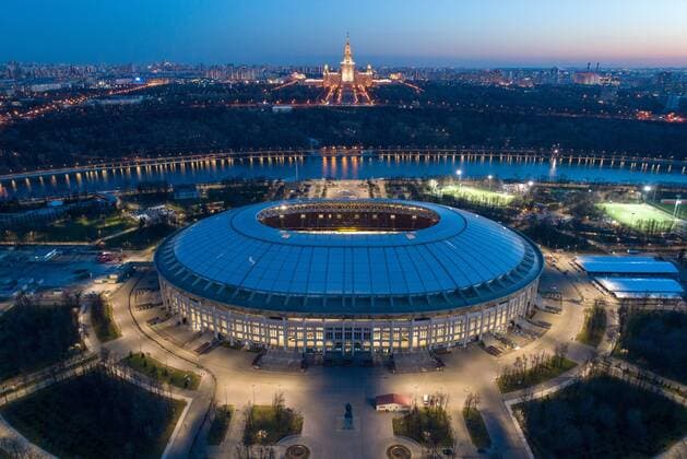 MOSCOW, RUSSIA - APRIL 23, 2018: An aerial view of Luzhniki Stadium, a venue for 2018 FIFA World Cup WM Weltmeisterschaft Fussball matches, lit at night with the main building of Lomonosov Moscow State University in the background. Dmitry Serebryakov TASS  TS07CEC1