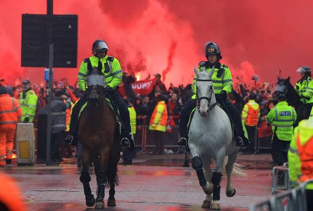 24th April 2018, Anfield, Liverpool, England; UEFA Champions League football, semi final, 1st leg, Liverpool versus AS Roma; mounted police escorting the Liverpool team bus emerge from the some flares lit by Liverpool fans on the approach to the stadium  ActionPlus12016809