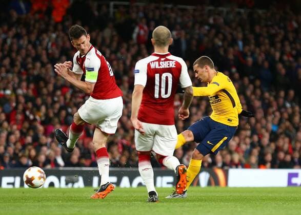 26th April 2018, Emirates Stadium, London, England; UEFA Europa League football, semi final, 1st leg, Arsenal versus Atletico Madrid; Antoine Griezmann of Atletico Madrid with a volley shot past Laurent Koscielny of Arsenal with Jack Wilshere of Arsenal looking on  ActionPlus12017272
