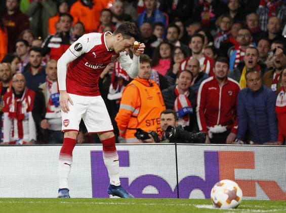 Arsenal s Mesut Ozil picks up an object thrown by Atletico?s fans during the Europa League Semi Final 1st Leg, match at the Emirates Stadium, London. Picture date: 26th April 2018. Picture credit should read: David Klein Sportimage EDITORIAL USE ONLY. No use with unauthorised audio, video, data, fixture lists, club league logos or live services. Online in-match use limited to 120 images, no video emulation. No use in betting, games or single club league player publications.