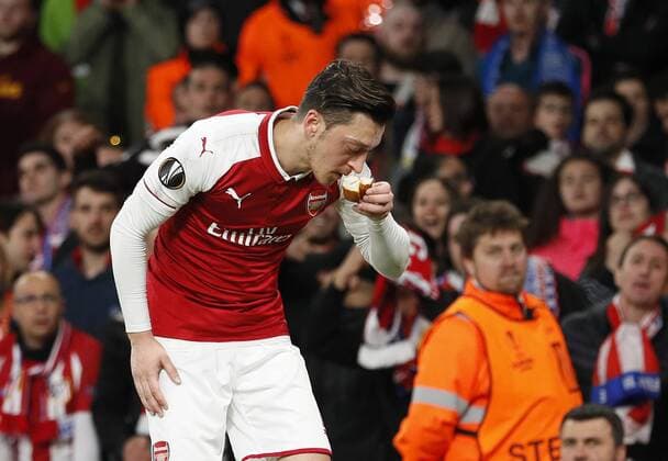 Arsenal s Mesut Ozil picks up and object thrown by the Atletico fans during the Europa League Semi Final 1st Leg, match at the Emirates Stadium, London. Picture date: 26th April 2018. Picture credit should read: David Klein Sportimage EDITORIAL USE ONLY. No use with unauthorised audio, video, data, fixture lists, club league logos or live services. Online in-match use limited to 120 images, no video emulation. No use in betting, games or single club league player publications.
