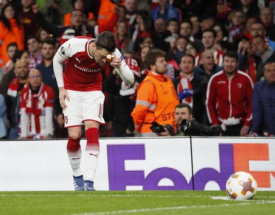 Arsenal s Mesut Ozil picks up and object thrown by the Atletico fans during the Europa League Semi Final 1st Leg, match at the Emirates Stadium, London. Picture date: 26th April 2018. Picture credit should read: David Klein Sportimage EDITORIAL USE ONLY. No use with unauthorised audio, video, data, fixture lists, club league logos or live services. Online in-match use limited to 120 images, no video emulation. No use in betting, games or single club league player publications.