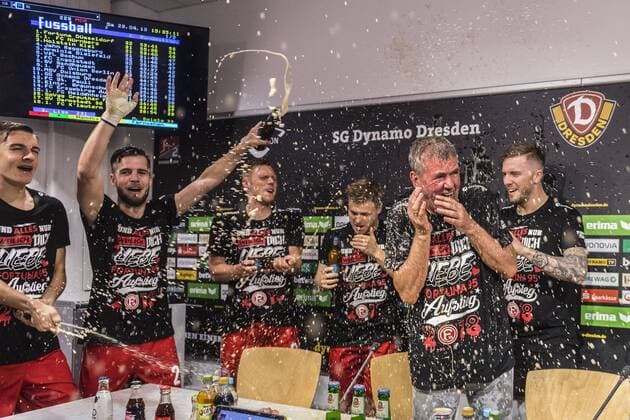 Fußball, 2. Bundesliga, Saison 2017 2018, SG Dynamo Dresden, 32. Spieltag, SG Dynamo Dresden - Fortuna Düsseldorf (28.04.2018), DDV - Stadion, Dresden. Düsseldorfs Trainer Friedhelm Funkel wird von seinen Spielern nach dem Aufstieg in die Bundesliga während der Pressekonferenz mit Bier geduscht. *** Football 2 Bundesliga Season 2017 2018 SG Dynamo Dresden 32 Matchday SG Dynamo Dresden Fortuna Dusseldorf 28 04 2018 DDV Stadion Dresden Dusseldorf coach Friedhelm Funkel is showered by his players after the promotion to the Bundesliga during the press conference with beer RM001