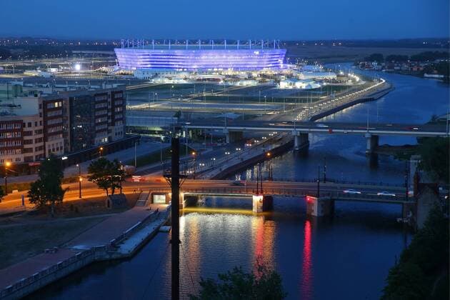 KALININGRAD, RUSSIA - MAY 11, 2018: An evening view of Oktyabrsky Island and Vysoky Most Bridge across the Staraya Pregolya River with Kaliningrad Stadium behind; the stadium is one of the venues of the forthcoming FIFA World Cup WM Weltmeisterschaft Fussball Russia 2018. Peter Kovalev TASS  TS07F360