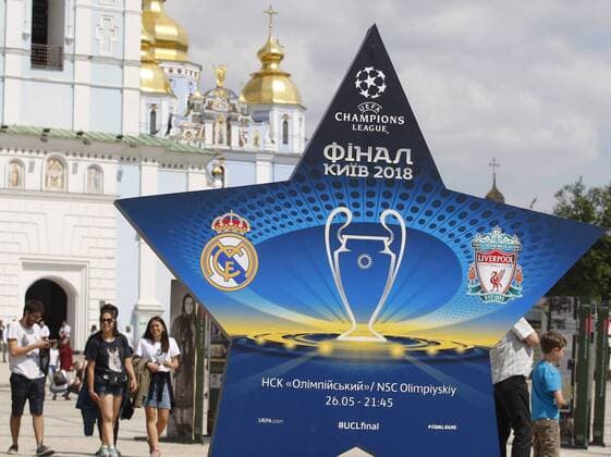 May 12, 2018 - Kiev, Ukraine - People walk past a large sign showcasing the logo for the 2018 UEFA Champions League Final in Kiev, Ukraine, 12 May, 2018. Kiev is preparing for the 2018 UEFA Champions League Final which will be played at the NSC Olimpiyskiy Stadium on May 26, 2018 and for the 2017-18 UEFA Women s Champions League final which will be played at Valeriy Lobanovskiy Dynamo Stadium on 24 May. 2018 UEFA Champions League Final in Kiev  - ZUMAn230 20180512_zaa_n230_568 Copyright: xStrx