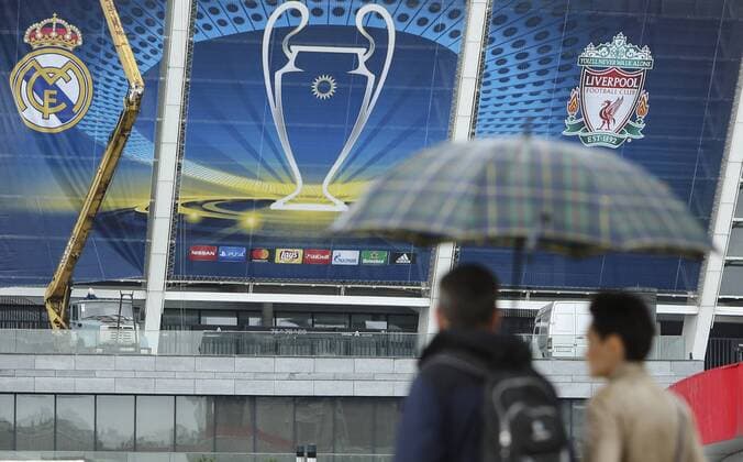 May 13, 2018 - Kiev, Ukraine - Couple under the umbrella walks past NSC Olimpiyskiy Stadium covered with banners for the Champions League in Kyiv, Ukraine, May 13, 2018. Kyiv prepares to host UEFA Women s Champions League final between Wolfsburg and Lyon at Valeriy Lobanovskiy Dynamo Stadium on 24 May, 2018 and the UEFA Champions League final match between Real Madrid and Liverpool at NSC Olimpiyskiy Stadium on Saturday 26 May, 2018. Kyiv prepares for UEFA Champions League final  - ZUMAn230 20180513_zaa_n230_898 Copyright: xSergiixKharchenkox