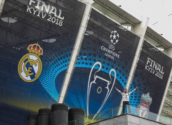 May 13, 2018 - Kiev, Ukraine - A man poses for a picture in front of NSC Olimpiyskiy covered with banners for the Champions League in Kyiv, Ukraine, May 13, 2018. Kyiv prepares to host UEFA Women s Champions League final between Wolfsburg and Lyon at Valeriy Lobanovskiy Dynamo Stadium on 24 May, 2018 and the UEFA Champions League final match between Real Madrid and Liverpool at NSC Olimpiyskiy Stadium on Saturday 26 May, 2018. Kyiv prepares for UEFA Champions League final  - ZUMAn230 20180513_zaa_n230_906 Copyright: xSergiixKharchenkox