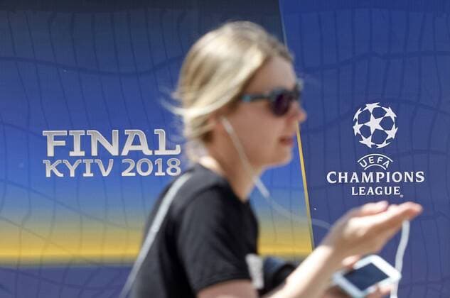 May 18, 2018 - Kiev, Ukraine - A girl walks in front of the UEFA Champions League Final 2018 logo, in center of Kiev, Ukraine, on 18 May 2018. Real Madrid will face Liverpool FC in the UEFA Champions League final at the NSC Olimpiyskiy stadium in Kiev on 26 May 2018. UKRAINE UEFA CHAMPIONS LEAGUE FINAL 2018 - ZUMAg194 20180518_zap_g194_001 Copyright: xSergxGlovnyx