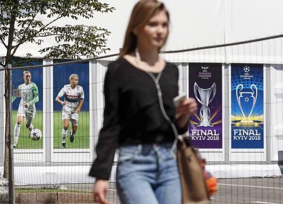 May 18, 2018 - Kiev, Ukraine - A girl walks in front of the UEFA Champions League Final 2018 logo, in center of Kiev, Ukraine, on 18 May 2018. Real Madrid will face Liverpool FC in the UEFA Champions League final at the NSC Olimpiyskiy stadium in Kiev on 26 May 2018. UKRAINE UEFA CHAMPIONS LEAGUE FINAL 2018 - ZUMAg194 20180518_zap_g194_008 Copyright: xSergxGlovnyx