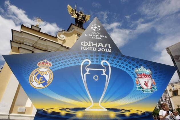 May 18, 2018 - Kiev, Ukraine - A woman walks past an installation with the logo of the UEFA Champions League final, in center of Kiev, Ukraine, on 18 May 2018. Real Madrid will face Liverpool FC in the UEFA Champions League final at the NSC Olimpiyskiy stadium in Kiev on 26 May 2018. UKRAINE UEFA CHAMPIONS LEAGUE FINAL 2018 - ZUMAg194 20180518_zap_g194_015 Copyright: xSergxGlovnyx
