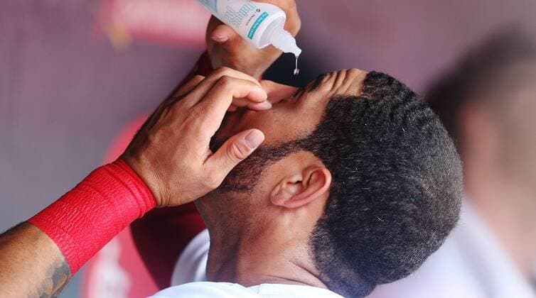 St. Louis Cardinals Tommy Pham applies eye drops in the dugout before a game against the Kansas City Royals at Busch Stadium in St. Louis on May 21, 2018.  SLP2018052112 BILLxGREENBLATT