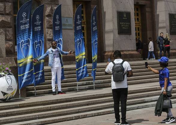 May 22, 2018 - Kiev, Ukraine - A woman poses for a picture in front of the flags with the UEFA Champions League final logo in central in Kyiv, Ukraine, May 22, 2018 Kiev Prepares For UEFA Champions League Final  - ZUMAn230 20180522_zaa_n230_790 Copyright: xSergiixKharchenkox