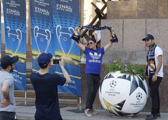 May 23, 2018 - Kiev, Ukraine - Real Madrid fans pose for a photo near a giant ball promoting the UEFA Champions League final in center of Kiev, Ukraine, on 23 May 2018. Real Madrid will face Liverpool FC in the UEFA Champions League final at the NSC Olimpiyskiy stadium in Kiev on 26 May 2018. UKRAINE UEFA CHAMPIONS LEAGUE FINAL 2018 - ZUMAg194 20180523_zap_g194_023 Copyright: xSergxGlovnyx