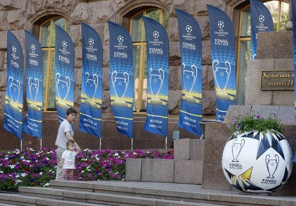 May 23, 2018 - Kiev, Ukraine - A woman with a child walk past banners promoting the UEFA Champions League final in center of Kiev, Ukraine, on 23 May 2018. Real Madrid will face Liverpool FC in the UEFA Champions League final at the NSC Olimpiyskiy stadium in Kiev on 26 May 2018. UKRAINE UEFA CHAMPIONS LEAGUE FINAL 2018 - ZUMAg194 20180523_zap_g194_026 Copyright: xSergxGlovnyx