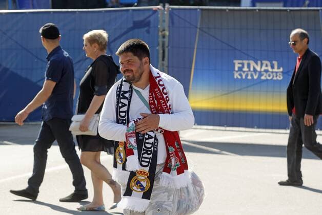 May 23, 2018 - Kiev, Ukraine - A street vendor walks with the scarfs with the symbols of teams participting UEFA Champions League final in center of Kiev, Ukraine, on 23 May 2018. Real Madrid will face Liverpool FC in the UEFA Champions League final at the NSC Olimpiyskiy stadium in Kiev on 26 May 2018. UKRAINE UEFA CHAMPIONS LEAGUE FINAL 2018 - ZUMAg194 20180523_zap_g194_029 Copyright: xSergxGlovnyx