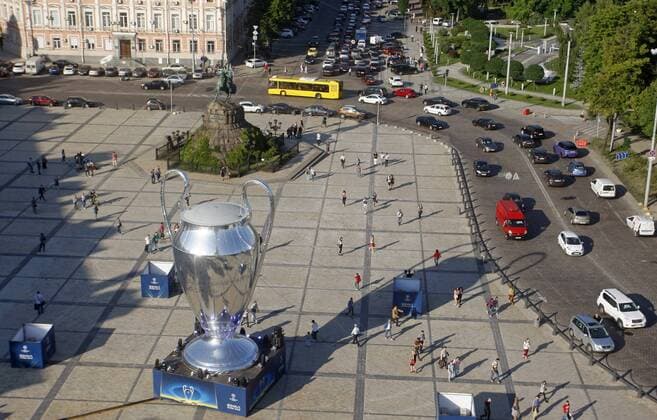 May 23, 2018 - Kiev, Ukraine - People walk next of a giant replica of the UEFA Champions League trophy in centr of Kiev, Ukraine, 23 May, 2018.Kiev is preparing for the 2018 UEFA Champions League Final football match between Real Madrid and Liverpool FC next May 26 at the Olimpiyskiy Stadium. Real Madrid v Liverpool - UEFA Champions League Final Previews  - ZUMAn230 20180523_zaa_n230_1171 Copyright: xStrx