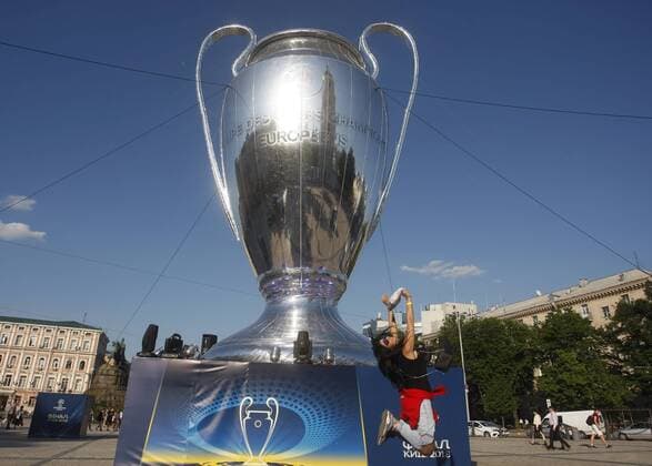 May 23, 2018 - Kiev, Ukraine - A woman poses for a photo in front of a giant replica of the UEFA Champions League trophy in centr of Kiev, Ukraine, 23 May, 2018.Kiev is preparing for the 2018 UEFA Champions League Final football match between Real Madrid and Liverpool FC next May 26 at the Olimpiyskiy Stadium. Real Madrid v Liverpool - UEFA Champions League Final Previews  - ZUMAn230 20180523_zaa_n230_1179 Copyright: xStrx