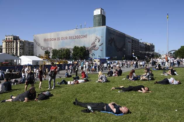 Fußball, CL-Finale, Fans vor dem Spiel May 26, 2018 - Kiev, Ukraine - Soccer fans lay on the grass as waiting for the kick-off at the Maidan Square, near the fan zone, in doiwntown Kyiv, Ukraine, prior to the UEFA Champions League Final between Real Madrid and Liverpool at NSC Olimpiyskiy Stadium on May 26, 2018 in Kiev, Ukraine. Real Madrid v Liverpool - UEFA Champions League Final Previews  - ZUMAn230 20180526_zaa_n230_794 Copyright: xMaxymxMarusenkox