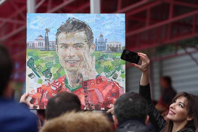 WM 2018, Ronaldo PortrÃ¤t aus Zeitungsausschnitten MOSCOW REGION, RUSSIA - JUNE 10, 2018: Football fans with a portrait of Portuguese football player Cristiano Ronaldo by artist Andrei Shatilov (not in picture) at Saturn Stadium in Kratovo, Moscow Region, where Portugal s national football team are having a training session ahead of the FIFA World Cup WM Weltmeisterschaft Fussball Russia 2018. Sergei Savostyanov TASS  TS083534