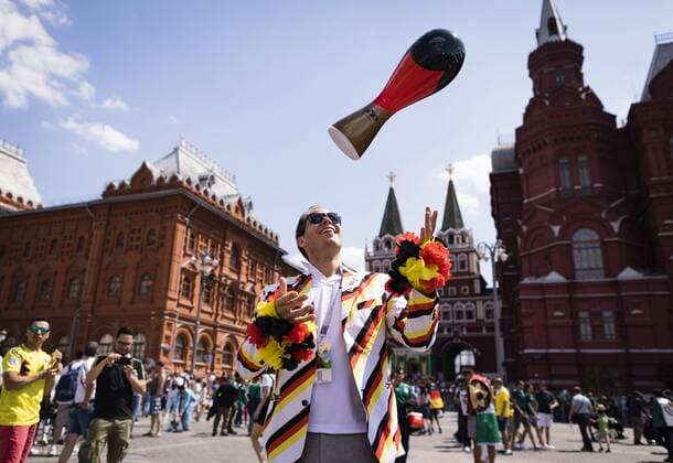 Moscow 17 06 2018 German fan throws World Cup trophy in Germany colors in front of the State Historical Museum Moscow in the air land and people