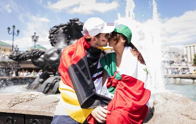 Moscow 17 06 2018 German Mexican couple kissing at a fountain in the Alexander Garden country and people