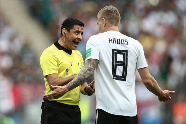 MOSCOW, RUSSIA - JUNE 17, 2018: Referee Alireza Faghani (L) and Germany s Toni Kroos in the 2018 FIFA World Cup WM Weltmeisterschaft Fussball Group F football match between Germany and Mexico at Luzhniki Stadium. Valery Sharifulin TASS  TS084C3E