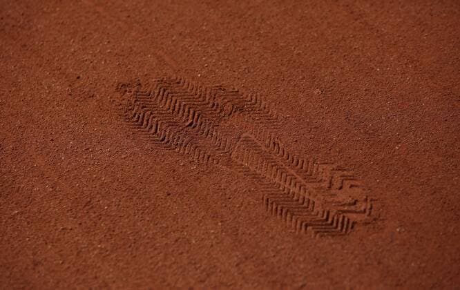 French open feature footprint in the red ash profile of a shoe detail closeup Copyright: xJuergenxHasenkopfx