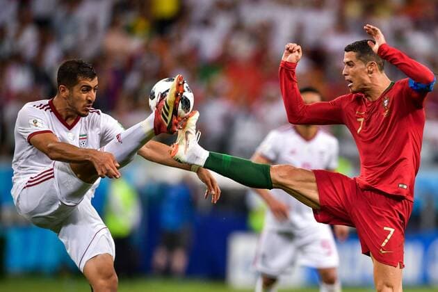 Cristiano Ronaldo of Portugal, right, challenges a player of Iran in their Group B match during the 2018 FIFA World Cup WM Weltmeisterschaft Fussball in Saransk, Russia, 25 June 2018.. Iran holds Portugal to 1-1 draw, but Portugal fights off Iran to advance in World Cup - FIFA Fußball WM  scr135046