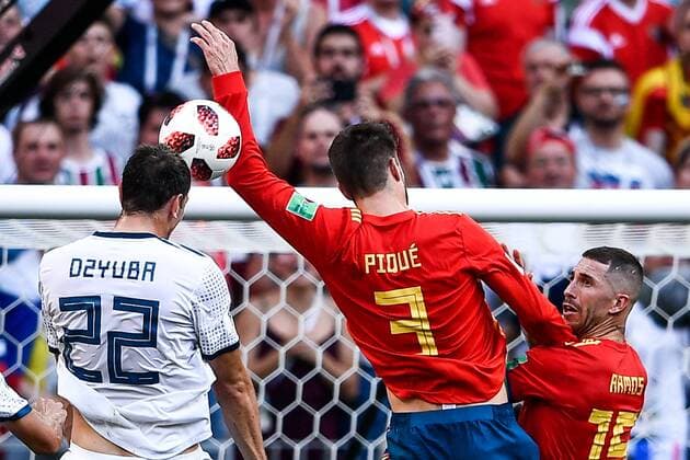 Artem Dzyuba of Russia, left, challenges Gerard Pique of Spain in their Round of 16 match during the 2018 FIFA World Cup WM Weltmeisterschaft Fussball in Moscow, Russia, 1 July 2018. Russia captain Igor Akinfeev saved two penalties in a dramatic shootout as the World Cup hosts dumped title contenders Spain out in the last 16 following a 1-1 draw. Veteran Russia centre-back Sergei Ignashevich gifted Spain the opening goal on 12 minutes in Moscow when he unwittingly turned into his own net after grappling with Sergio Ramos. Russia hit back just before the interval as Artem Dzyuba nervelessly converted a penalty awarded for a handball by Gerard Pique. Spain controlled the game as expected but struggled to create genuine chances, with Akinfeev sharp on the few occasions they did before saving from Koke and Iago Aspas to seal a 4-3 win on penalties. Russia beat Spain 4-3 on penalties to reach World Cup quarter-finals  20180701_09529
