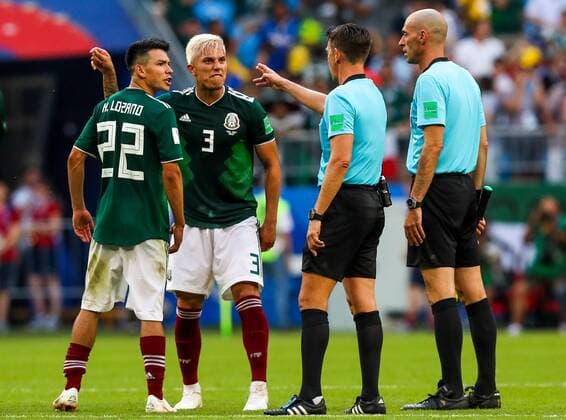 SAMARA, RUSSIA - JULY 2, 2018: Mexicoâ€™s Hirving Lozano, Carlos Salcedo, and referee Gianluca Rocchi (L-R) after their 2018 FIFA World Cup WM Weltmeisterschaft Fussball Round of 16 match against Brazil at Samara Arena Stadium; Brazil wins 2-0. Sergei Savostyanov TASS  TS0879D3