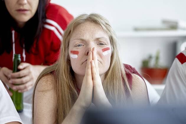 Sports enthusiasts anxiously watching match on TV  Copyright: BelenxMajdalani B82068638