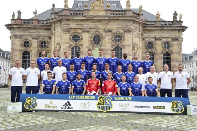 The team of the 1 FC Saarbrücken on Thursday 12 07 2018 in front of the Ludwigskirche in Saarbrücken In the picture Upper row from Marco Holz 14 Macel Carl 22 Steven Zellner 5 Alexandre Mendy 4 Benjamin Kessel 15 Oliver Oschkenat 3 Nino Miotke 28 José Pierre Vunguidica 9 Sebastian Jacob 24 and Marco Kehl Gomez Intermediate Series Robert Roelofsen Co Trainer Dirk Lottner Head Coach Christoph Fuhr Athletic Trainer Heinz Böhmann Goalkeeper Coach Gillian Jurcher 21 Lukas Quirin 31 Markus Obernosterer 10 Manuel Zeitz 8 Tobias Jänicke 25 Pierre Fassnacht 29 Helmut Schwan Supervisor Rüdiger Schmid Kit Officer Paulo da Palma Physiotherapist and Frank Kackert Goalkeeper Coach Bottom row by Fatih Köksal 27 Sascha Wenninger 19 Fanol Perdedaj 17 Ricco Cymer 20 Daniel Batz 1 Martin Dausch 7 Markus Mendler 11 and Mario Müller 23