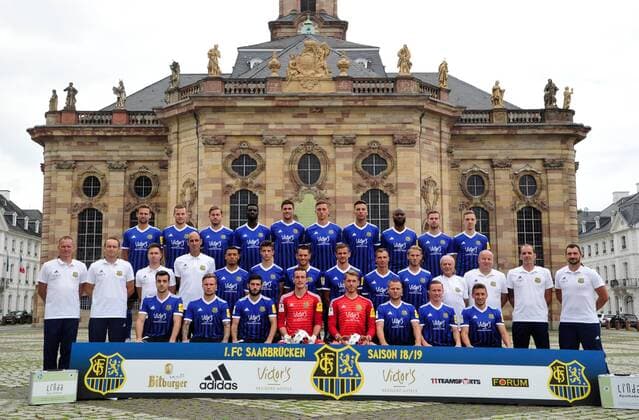 The team of the 1 FC Saarbrücken on Thursday 12 07 2018 in front of the Ludwigskirche in Saarbrücken In the picture Upper row from Marco Holz 14 Macel Carl 22 Steven Zellner 5 Alexandre Mendy 4 Benjamin Kessel 15 Oliver Oschkenat 3 Nino Miotke 28 Jose Pierre Vunguidica 9 Sebastian Jacob 24 and Marco Kehl Gomez Intermediate Series Robert Roelofsen Co Trainer Dirk Lottner Head Coach Christoph Fuhr Athletic Trainer Heinz Böhmann Goalkeeper Coach Gillian Jurcher 21 Lukas Quirin 31 Markus Obernosterer 10 Manuel Zeitz 8 Tobias Jänicke 25 Pierre Fassnacht 29 Helmut Schwan Supervisor Rüdiger Schmid Kit Officer Paulo da Palma Physiotherapist and Frank Kackert Goalkeeper Coach Bottom row by Fatih Köksal 27 Sascha Wenninger 19 Fanol Perdedaj 17 Ricco Cymer 20 Daniel Batz 1 Martin Dausch 7 Markus Mendler 11 and Mario Müller 23
