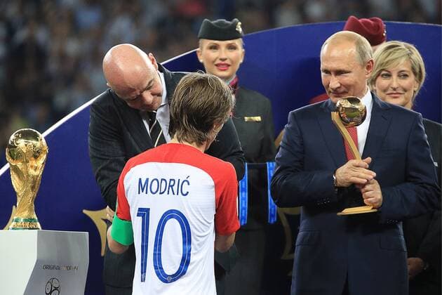 MOSCOW, RUSSIA â€“ JULY 15, 2018: FIFA President Gianni Infantino and Russia s President Vladimir Putin (L-R back) present Croatia s forward Luka Modric (front) with the Ballon d Or at a victory ceremony after the 2018 FIFA World Cup WM Weltmeisterschaft Fussball final football match between France and Croatia at Luzhniki Stadium. Team France won the game 4:2 and claimed the World Cup title. Sergei Bobylev TASS  TS089A99