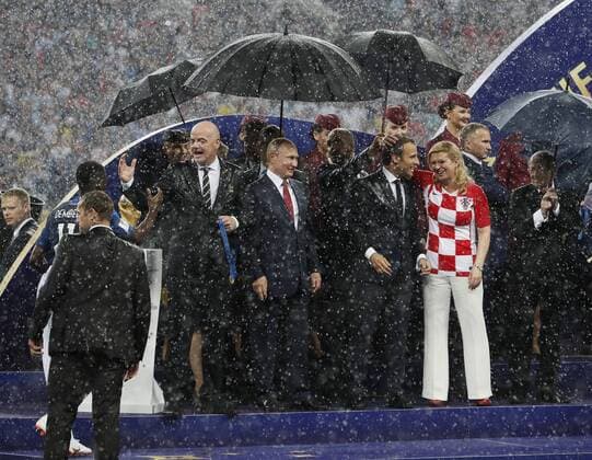FIFA President Gianni Infantino, Russia President Vladimir Putin, French President Emmanuel Macron and Croation Kolinda Grabar-Kitarovic stand in the rain during the FIFA World Cup WM Weltmeisterschaft Fussball 2018 Final at the Luzhniki Stadium, Moscow. Picture date 15th July 2018. Picture credit should read: David Klein Sportimage EDITORIAL USE ONLY. No use with unauthorised audio, video, data, fixture lists, club league logos or live services. Online in-match use limited to 120 images, no video emulation. No use in betting, games or single club league player publications.