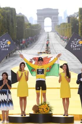 British Geraint Thomas of Team Sky wearing the yellow jersey of overall leader and holding a Welsh flag celebrates on the podium after the last stage of the 105th edition of the Tour de France cycling race, 116km from Houilles to Paris, France, Sunday 29 July 2018. This year s Tour de France takes place from July 7th to July 29th. POOLxSTEPHANExMANTEY  x05395123x