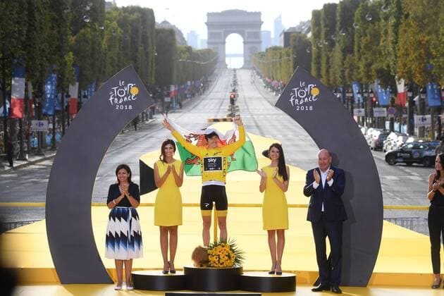 British Geraint Thomas of Team Sky wearing the yellow jersey of overall leader and holding a Welsh flag celebrates on the podium after the last stage of the 105th edition of the Tour de France cycling race, 116km from Houilles to Paris, France, Sunday 29 July 2018. This year s Tour de France takes place from July 7th to July 29th. POOLxSTEPHANExMANTEY  x05395124x